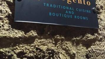 A sign for 'D'Argento' with text indicating it offers traditional cuisine and boutique rooms.