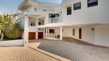 Un edificio residenziale a più piani con un cortile centrale, balconi e una pianta grande in primo piano.