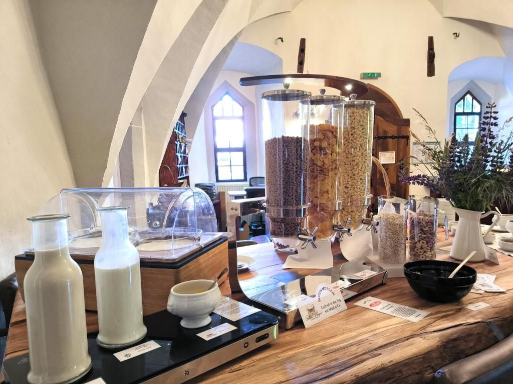 A café interior with a wooden counter displaying various food items and containers.