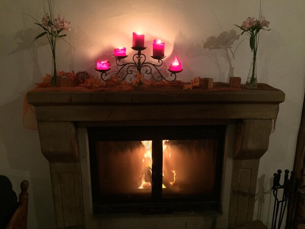 A fireplace with a mantel decorated with candles and flowers. - Schloss Wurzen (Wurzen)
