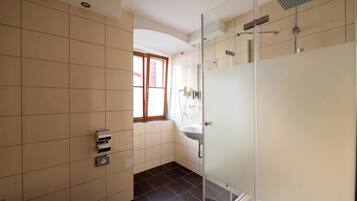 A modern bathroom with a toilet, a sink, and a shower area.