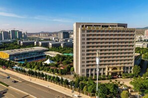 A multi-story hotel with a central courtyard, surrounded by greenery and a parking area. - Yunnan Lishui Yunquan Hotel (Yunshida South High-speed Railway Station) (Kunming)