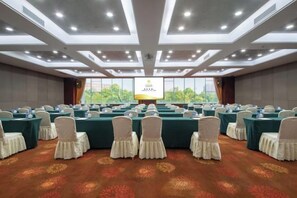A conference room with rows of tables, chairs, and a large screen at the front. - Yunnan Lishui Yunquan Hotel (Yunshida South High-speed Railway Station) (Kunming)