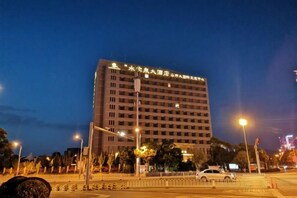Een hotel met meerdere verdiepingen, een platte gevel en een gelijkmatig raamritme.