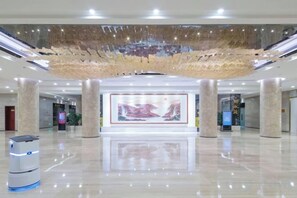 Un hall amplio con una gran exhibición de arte digital, un quiosco de autoservicio y un piso limpio y brillante.