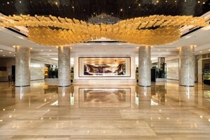 A spacious lobby with a large central artwork, polished marble flooring, and a distinctive ceiling installation. - Yunnan Lishui Yunquan Hotel (Yunshida South High-speed Railway Station) (Kunming)
