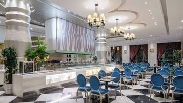 A hotel lobby with a check-in counter, seating area with chairs, and a decorative ceiling.