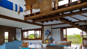 A spacious room with a wooden dining table, blue chairs, and a blue sofa.