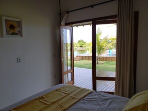A bedroom with a bed, a sliding glass door leading to a deck, and a framed picture on the wall.