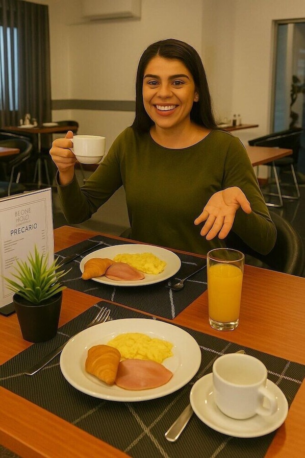 En frukostuppläggning med en tallrik innehållande ägg, skinka och en croissant, ett glas apelsinjuice och en kopp kaffe, placerat på en servett.