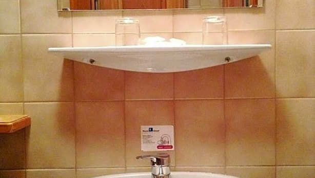 A bathroom with a white sink, a mirror above it, and a wooden cabinet below. - Grünes Türl (Bad Schallerbach)