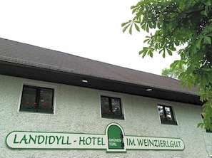 Un bâtiment sur lequel on peut lire l’inscription suivante : « LANDIYYL – HÔTEL GRÜNES TÜR IM WEINZIERLGUT ».