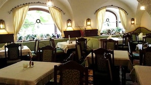 An interior with tables and chairs, arched ceilings, and windows with curtains. - Grünes Türl (Bad Schallerbach)