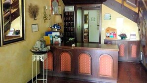 A reception area with a counter, a staircase, and a view of the interior.