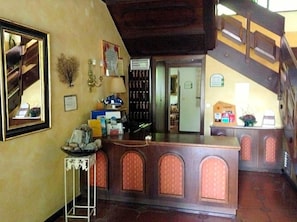 A reception area with a counter, a staircase, and a view of the interior.