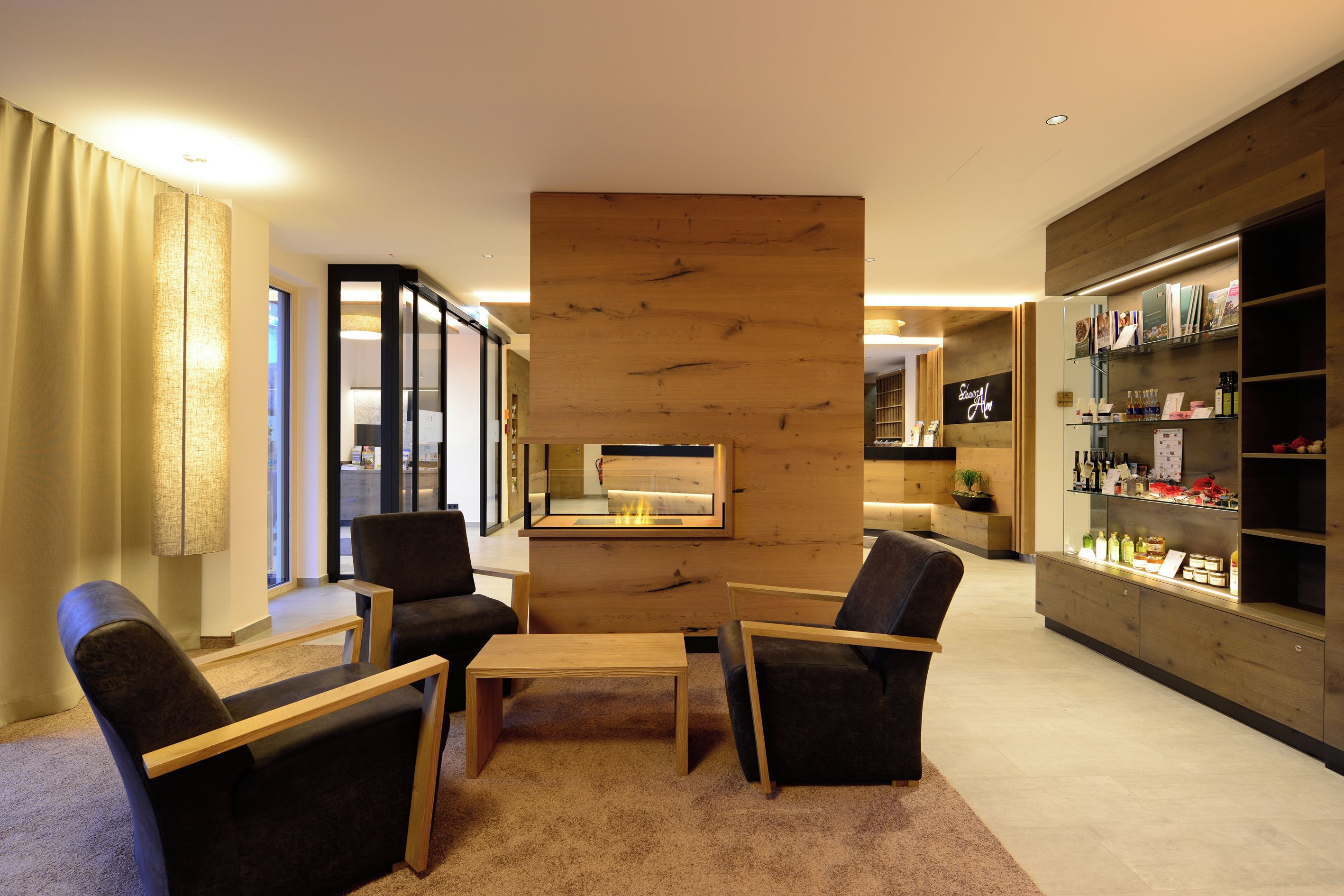 A modern hotel lobby with a reception desk, seating area, and a display of amenities.