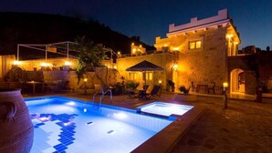 A stone building with a swimming pool and outdoor seating area. - Nikolas Villas Kamilari (Faistos)