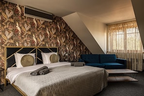 Un dormitorio con cama, sofá, televisión y ventana con cortinas.