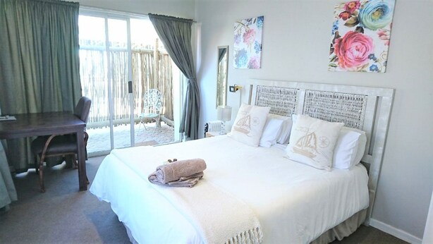 A bedroom with a bed, a desk, and a chair.