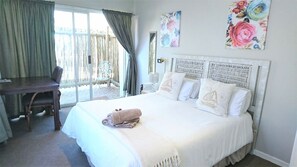 Een slaapkamer met een bed, een bureau en een stoel.
