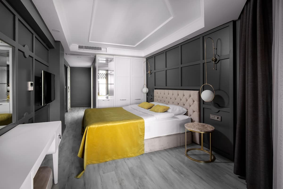 Un dormitorio moderno con una cama grande, mesitas de noche, un escritorio y un armario.