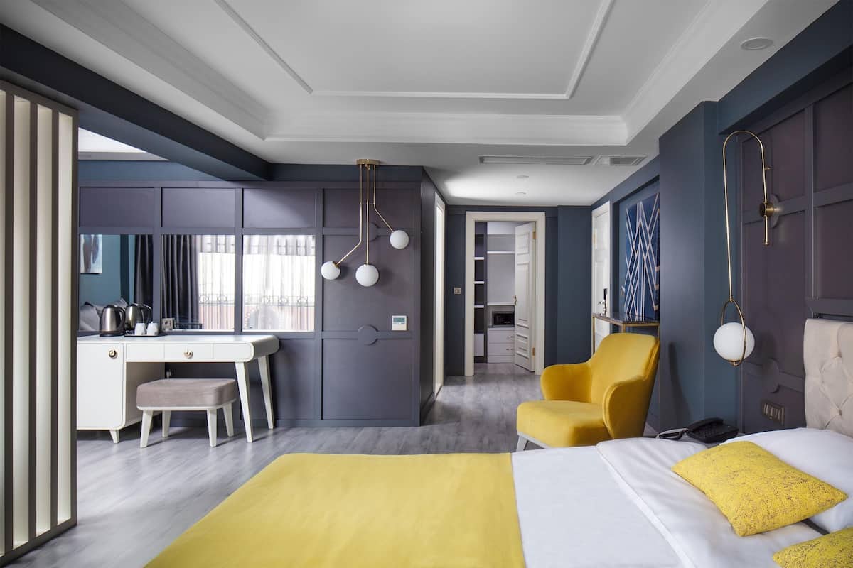 Una habitación de hotel con cama, escritorio, silla y armario.