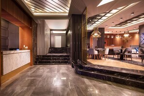 A modern hotel lobby with a marble staircase, a reception desk, and contemporary lighting fixtures. - B Loft Hotel Bursa (Bursa)