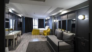 Una habitación de hotel moderna con sofá, escritorio, silla y cama.
