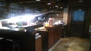 A bar area with a counter, stools, and a tiled floor. - Gasthof Schatzl (Grieskirchen)
