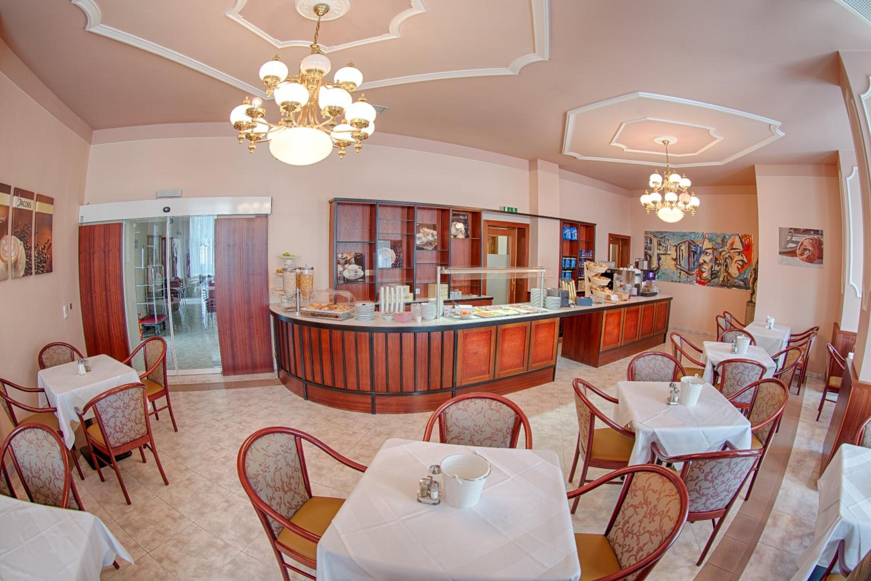A restaurant with a central bar, multiple dining tables, and chairs.