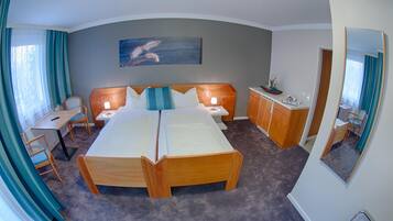A hotel room with a double bed, a desk, a chair, a cabinet, and a painting on the wall.