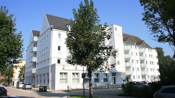 A multi-story hotel with a flat facade, balconies, and a clear sky.