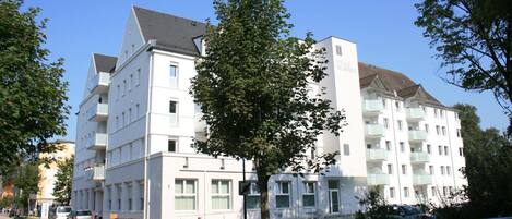 Een hotel met meerdere verdiepingen, een platte gevel, balkons en een heldere lucht.