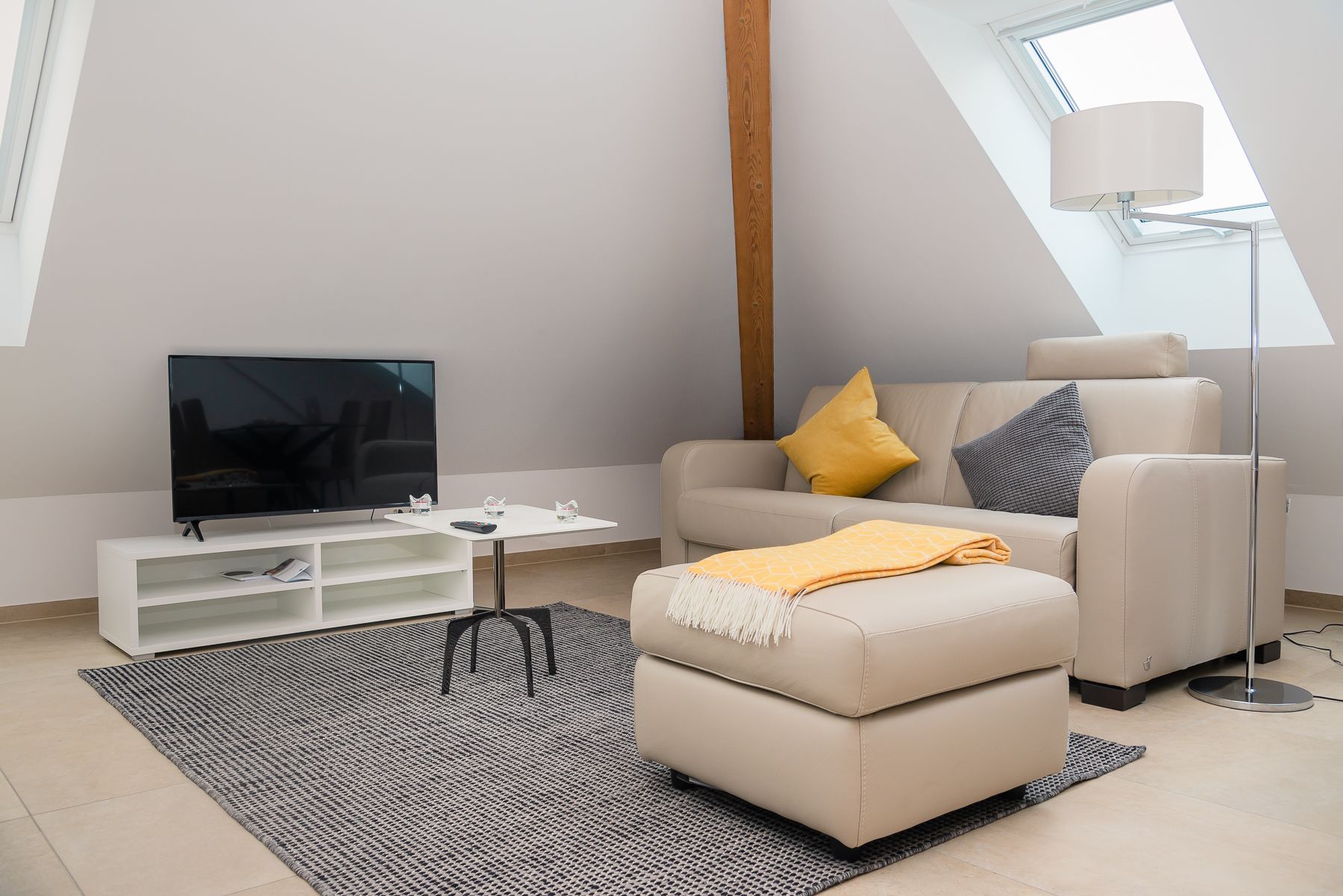 A modern living room with a flat-screen TV, a sofa, and a coffee table.