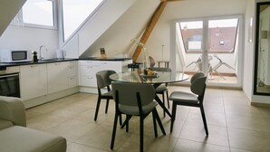 A modern kitchen with a dining area, large windows, and a view of the outside. - Zurich Furnished Homes (Zürich)