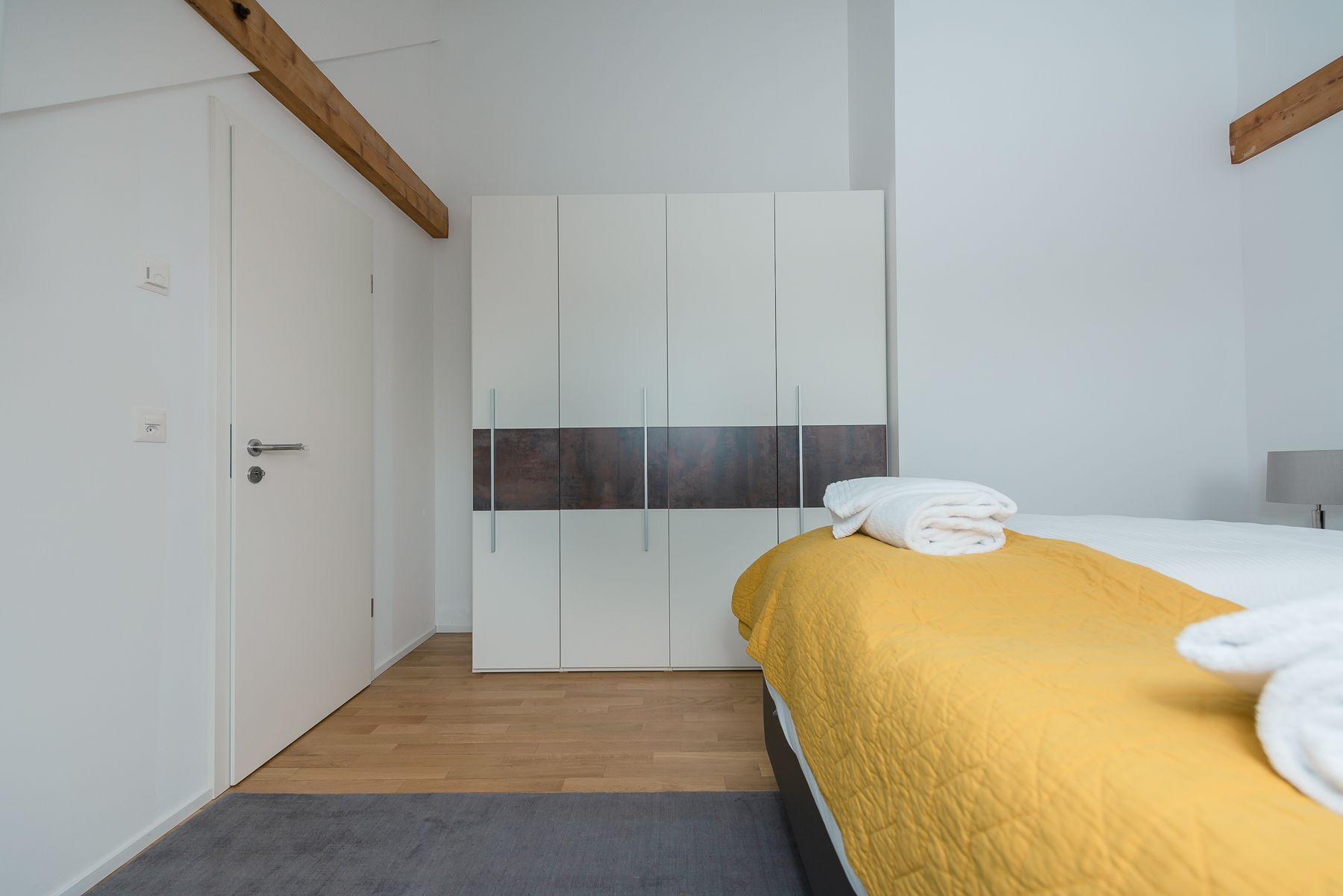 Ein Schlafzimmer mit Bett, Kleiderschrank und Tür.