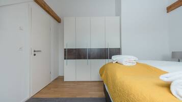 Ein Schlafzimmer mit Bett, Kleiderschrank und Tür.