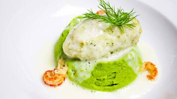Prato com molho cremoso, purê verde e guarnição de endro.