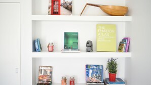 Une bibliothèque remplie de livres, un bol et des objets décoratifs.