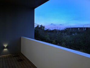 A balcony with a view of a building and vegetation.