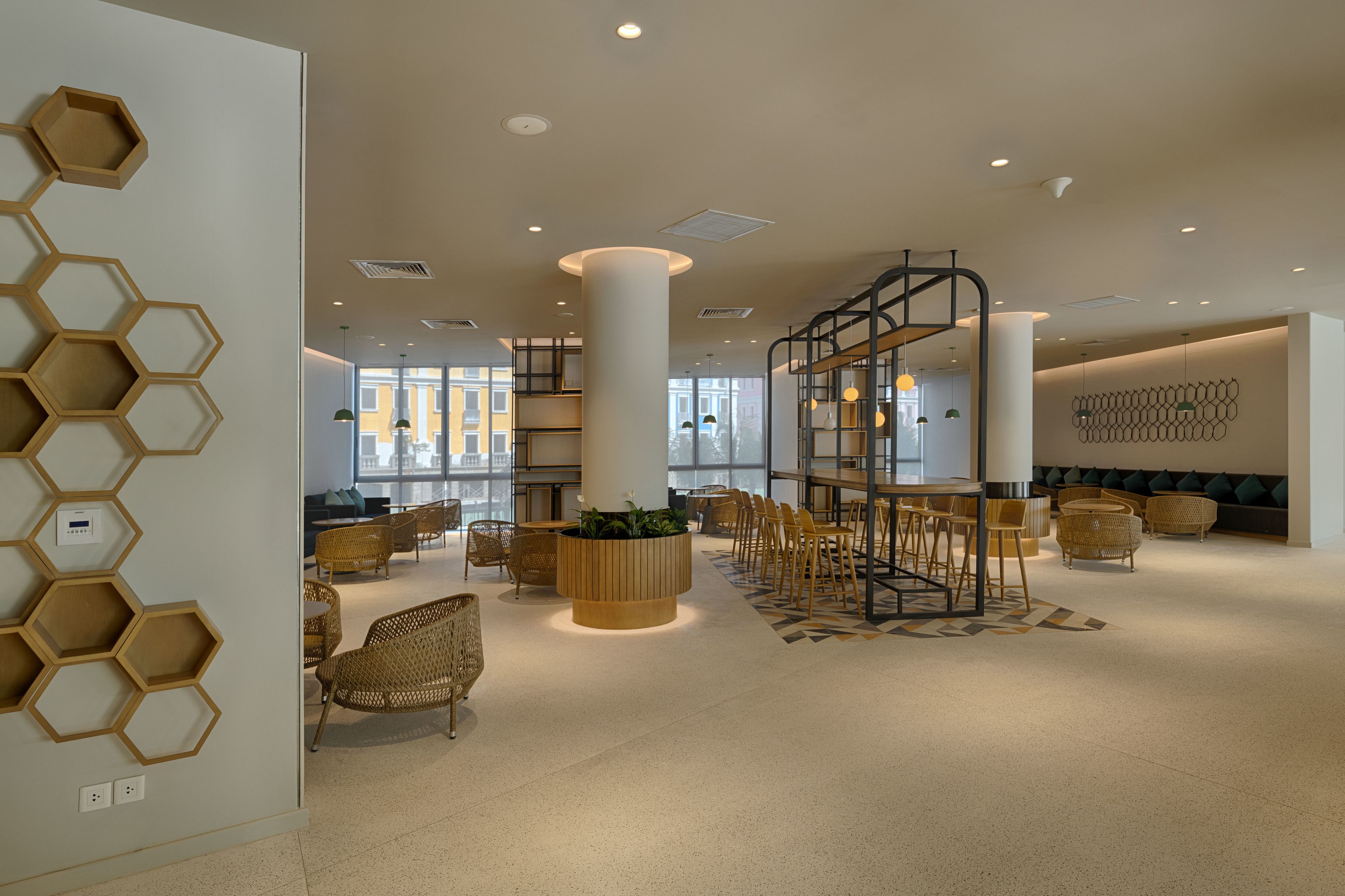 A spacious lobby with a central seating area, a large column, and a hexagonal wall design.