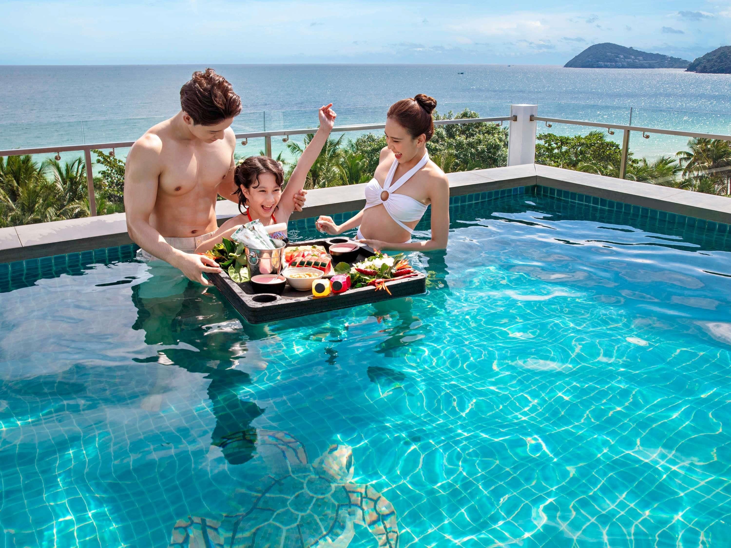 A poolside scene with a clear view of the ocean and a distant island.