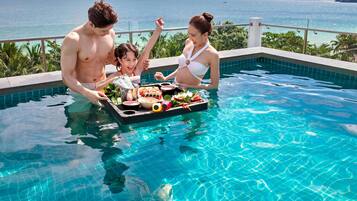 A poolside scene with a clear view of the ocean and a distant island.