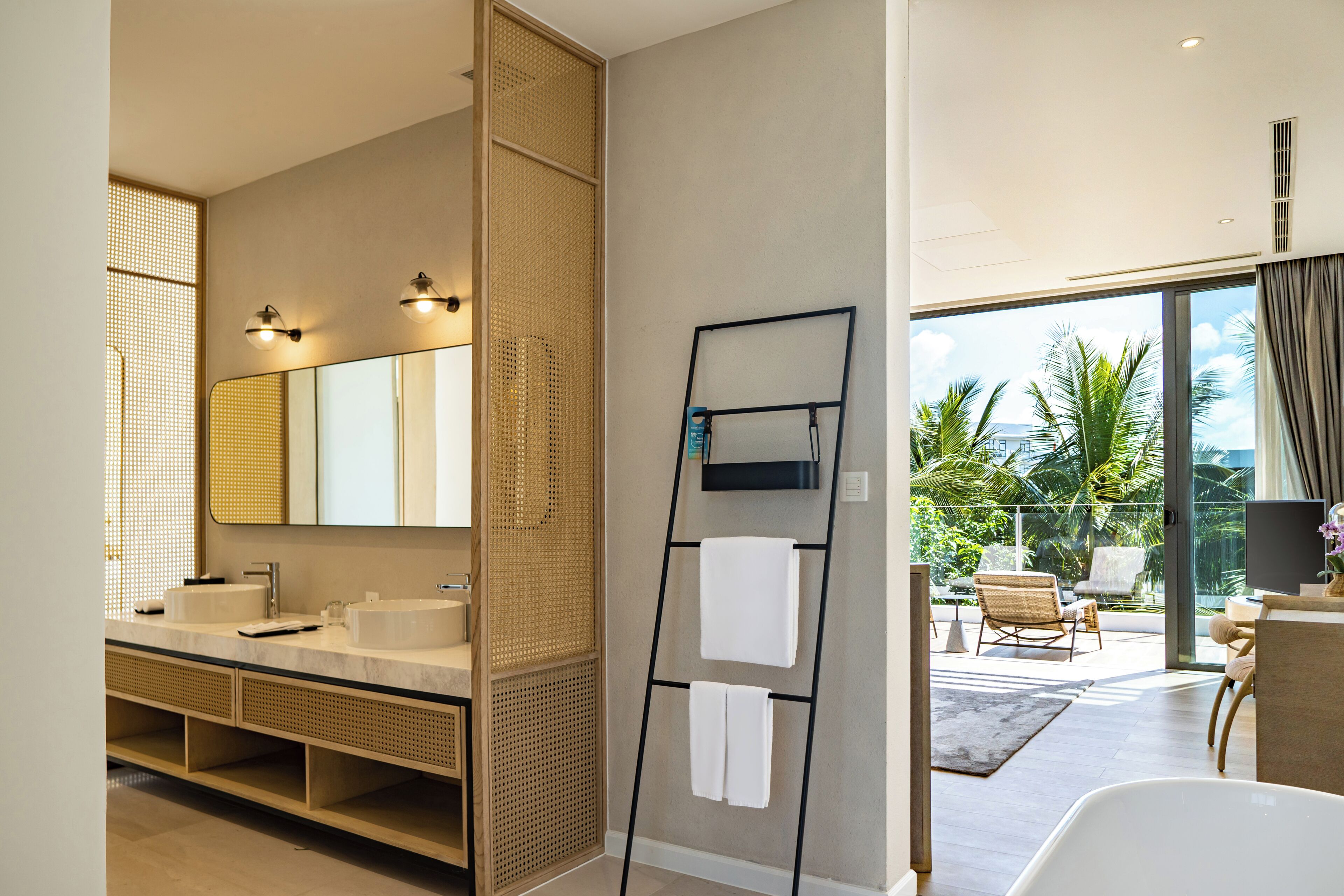 A modern bathroom with a large mirror, dual sinks, and a towel rack.