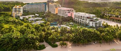 Un complejo turístico con varias edificaciones, una playa y una zona de piscina.