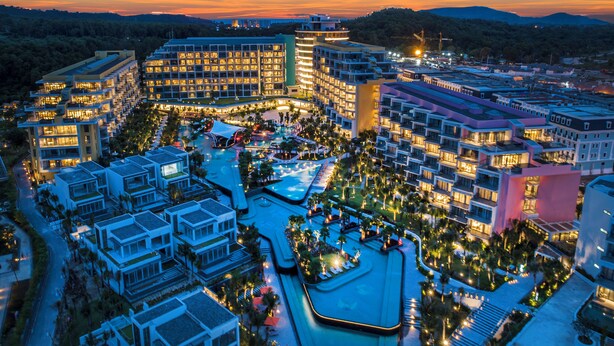 Un complejo hotelero con varias edificaciones, un patio central y una piscina.