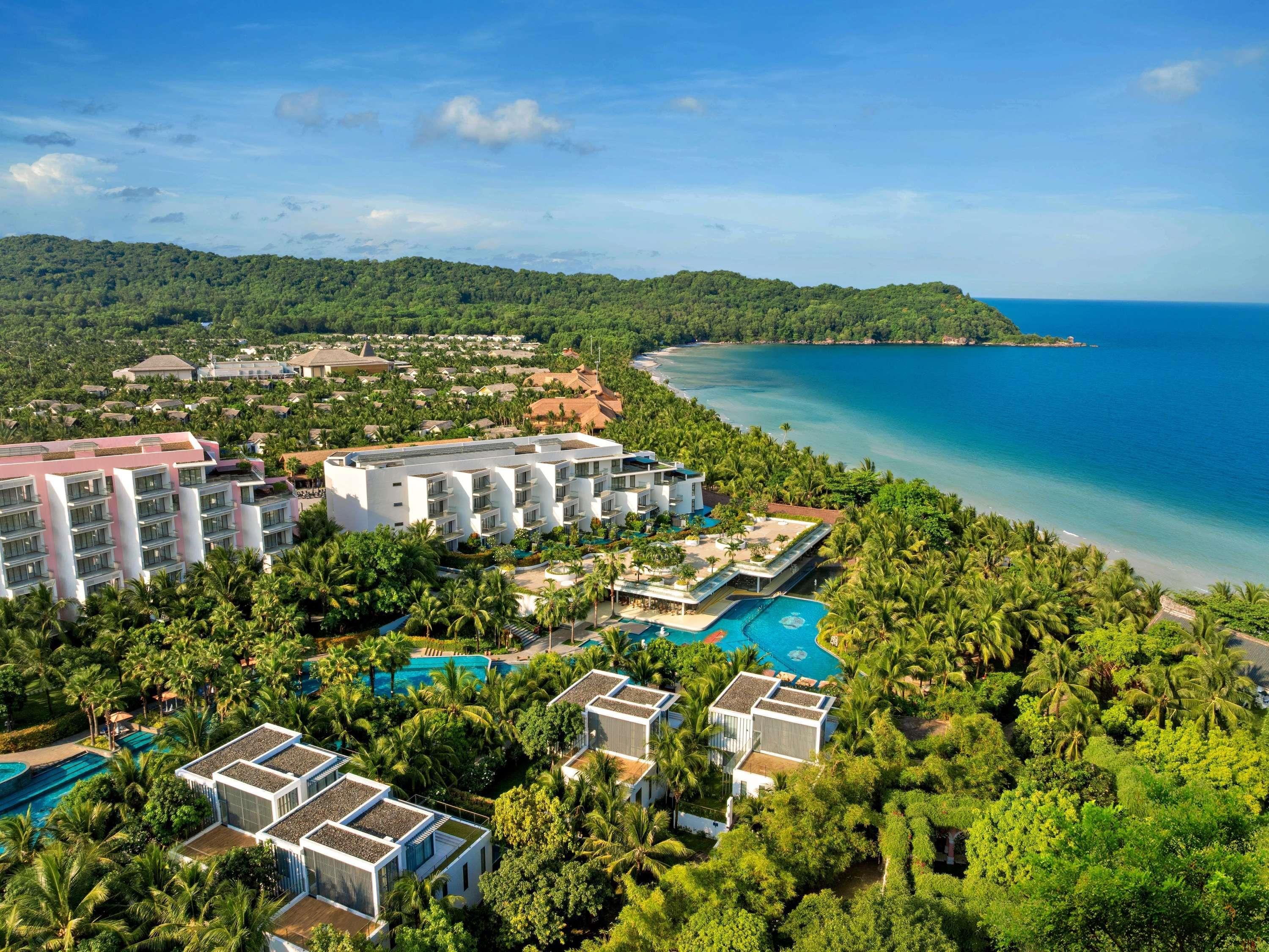 Un resort con varias edificaciones, una piscina y una playa.