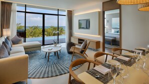 Una habitación de hotel moderna con un balcón grande, un comedor y un televisor montado en la pared.