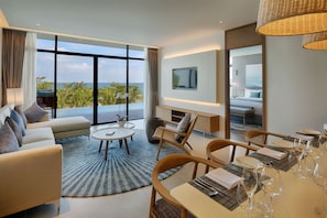 Una habitación de hotel moderna con un balcón grande, un comedor y un televisor montado en la pared.