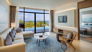 Una sala de estar moderna con un ventanal grande, un sofá, una mesa de centro y un televisor montado en la pared.